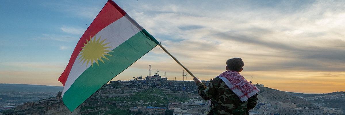 Le garçon tient un drapeau du Kurdistan
